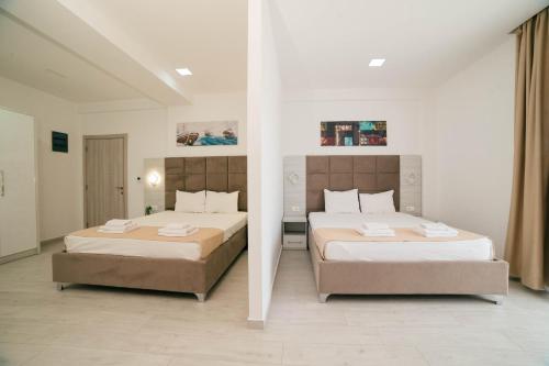 two beds in a large room with two beds sidx sidx sidx at Capital Rooms in Ulcinj