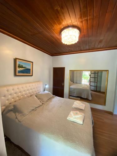 a bedroom with a large bed with a mirror at Aconchego Corrêas in Petrópolis