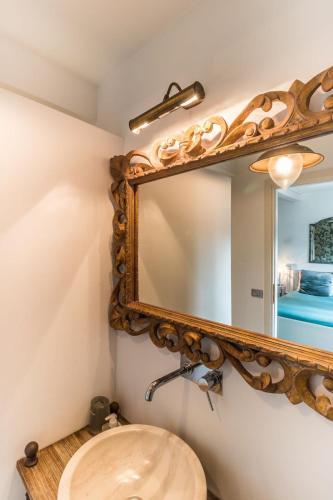 un baño con espejo y lavabo en Riad Rooms, en Sarnico