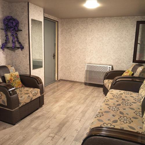 a living room with two chairs and a couch and a fan at Guesthouse - Happy house in Kutaisi in Kutaisi