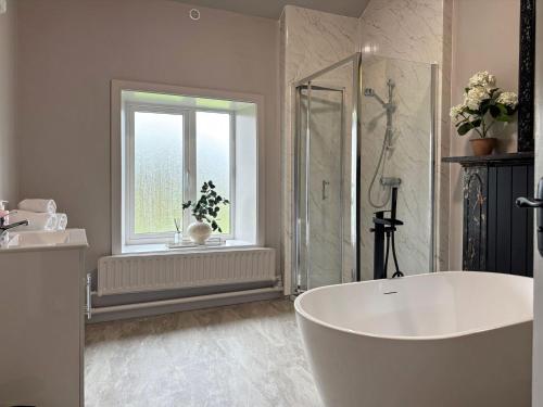 a white bathroom with a tub and a window at Property 472 - Kylemore in Kylemore