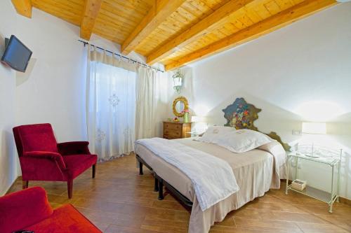Le Case Dello Zodiaco albergo diffuso في موديكا: غرفة نوم بسرير كبير وكرسي احمر