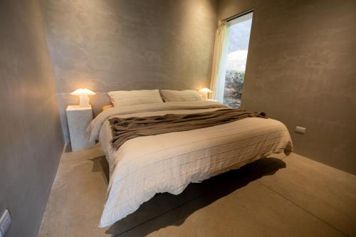 a bedroom with a large bed and a window at Garden Treehouse Ikhaya in Refundores