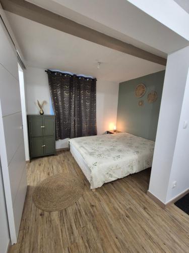 a bedroom with a bed and a large window at Studio Les Sapins in Chapois