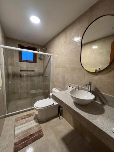 a bathroom with a toilet and a sink and a mirror at Aconchego Corrêas in Petrópolis