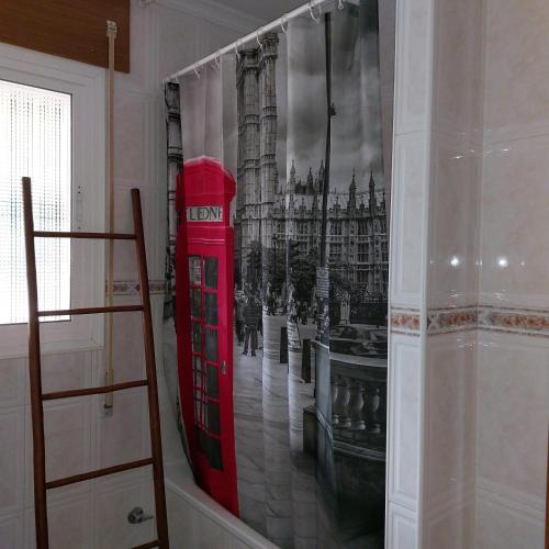 a room with a red phone booth and a picture of big ben at La Casuca in El Pelayo