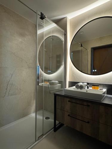 a bathroom with a shower and a sink and a mirror at Baltic Infinity Suite 314 - SPA & Pool Access in Międzyzdroje
