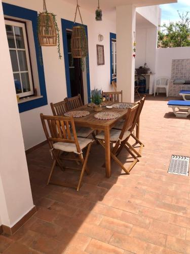 a wooden table and chairs on a patio at Pé na Areia, Alojamento Local in Porto Covo