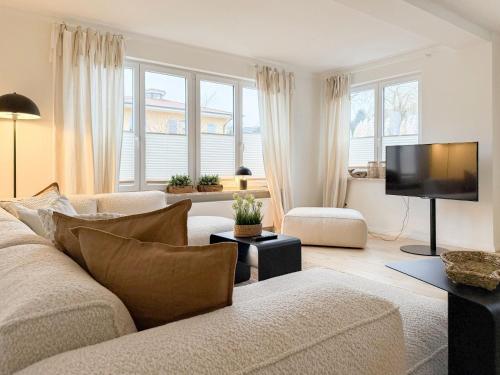 a living room with a couch and a flat screen tv at Cozy Home in Timmendorfer Strand