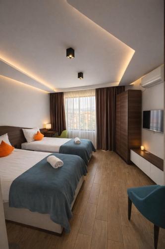 a hotel room with two beds and a television at Apel Luxury in Niš