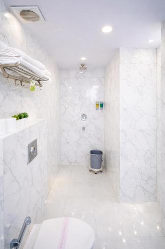 a white bathroom with a sink and a toilet at Hotel Golden Oasis - 5 Minute Walk from New Delhi Railway Station in New Delhi