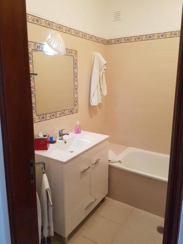 a bathroom with a sink and a tub and a mirror at Casa do Cabo de Santa Maria in Sagres