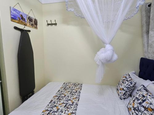 a bedroom with a bed and a window with a curtain at Favoured Brink in Nairobi