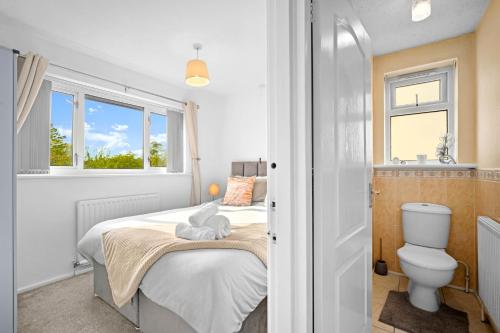 a small bedroom with a bed and a toilet at Solihull 5 Bed Home near NEC/Bham airport/JLR/HS2 in Solihull