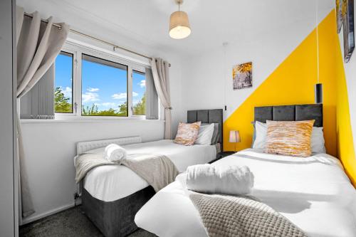 a bedroom with two beds and a window at Solihull 5 Bed Home near NEC/Bham airport/JLR/HS2 in Solihull