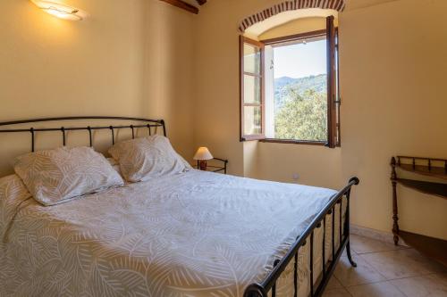 a bedroom with a bed with a window and a bed sidx sidx sidx at Maisonnette Chez Aurèle in Santa-Maria-di-Lota