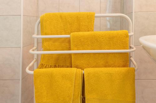 four yellow towels on a towel rack in a bathroom at Maisonnette Chez Aurèle in Santa-Maria-di-Lota