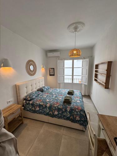 a bedroom with a bed and a table and a window at Céntrico duplex con piscina in Jávea