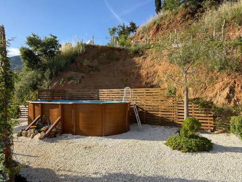a hot tub sitting in front of a hill at Glamping Finca el Olivo in Mijas