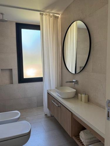 a bathroom with a sink and a mirror at Casa Cortaderas, Barrio Quequén Chico in Necochea