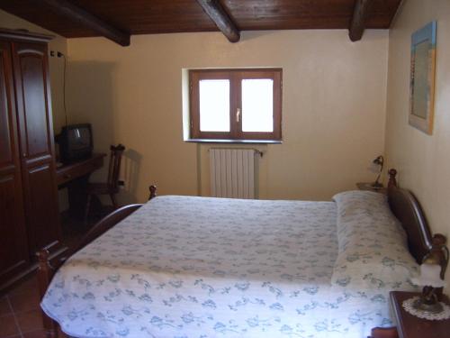 a bedroom with a bed and a window at Agriturismo La Grotta in Corbara