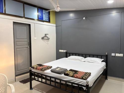 a bed with two pillows on it in a room at Datta Swami Homestay in Malvan