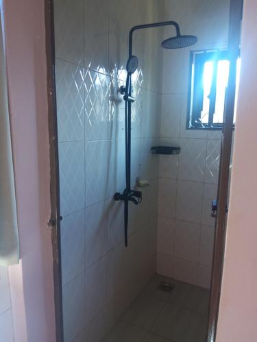 a shower with a glass door in a bathroom at Cae Cozy Home in Karatu