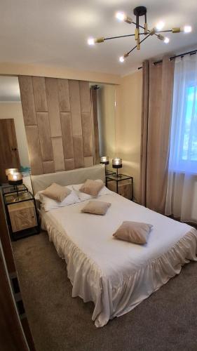 a bedroom with a large white bed with two pillows at Umińskiego Spacious Apartment in Poznań