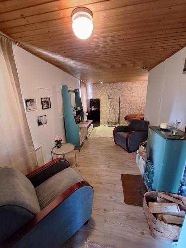 a living room with couches and a wooden ceiling at Saunamökki in Helsinki