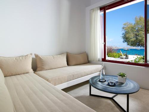 a living room with a couch and a table at Unique Milos Suites in Pollonia