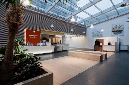 a lobby with a palm tree in a building at easyHotel Amsterdam Zaandam in Zaandam