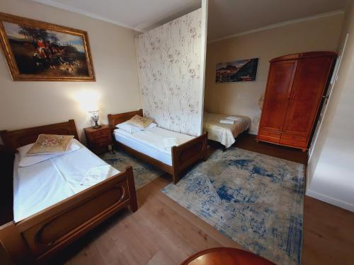 a small bedroom with two beds and a dresser at Rezydencja Rosa in Przemyśl