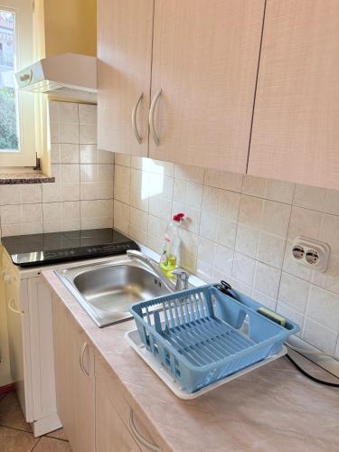 a kitchen with a sink and a dish basket on the counter at Guest house Ivo in Lovran