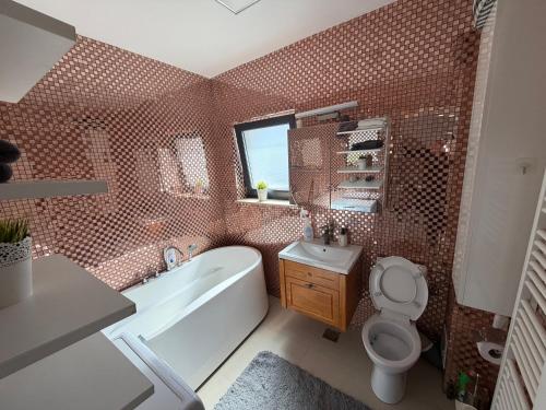 a bathroom with a tub and a toilet and a sink at Biby apartament in Cluj-Napoca