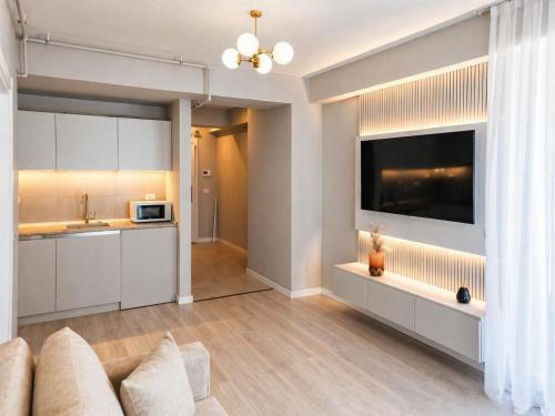 a living room with a couch and a large television at Crystal by Solid Sea View Mamaia - Apartament langa plaja cu vedere la mare in Mamaia