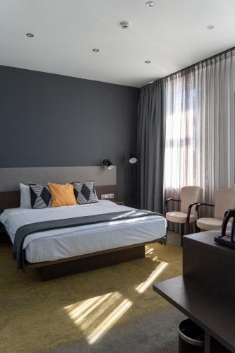 ein Schlafzimmer mit einem großen Bett und einem Fenster in der Unterkunft Hotel Kolumbs in Liepāja