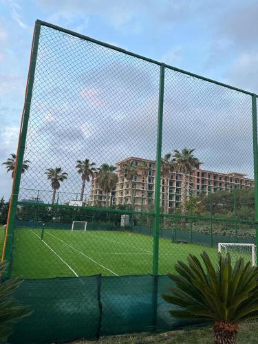 a tennis court in front of a building at Azure Pine Apartament in Golem