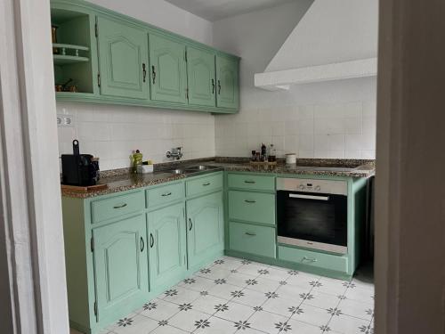 a kitchen with green cabinets and a tile floor at Raízes da Serra - Casa Lapa in Lapa dos Dinheiros