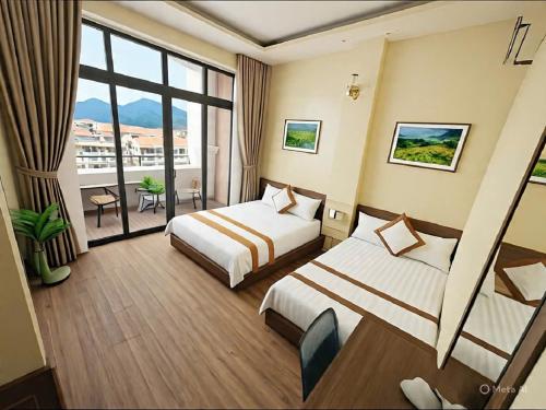 a hotel room with two beds and a balcony at Brother Friendly - Gia Cat Long Hotel in Cat Ba