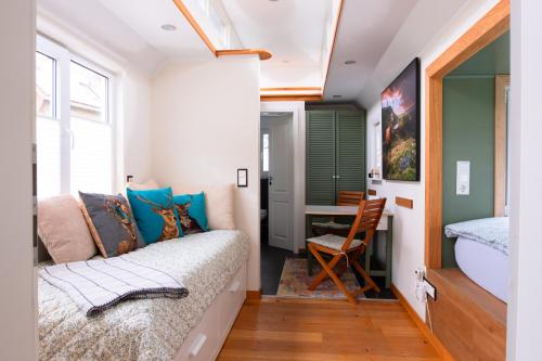 a small bedroom with a bed and a desk at Ilsehof Tiny-House Mimi in Osterwieck