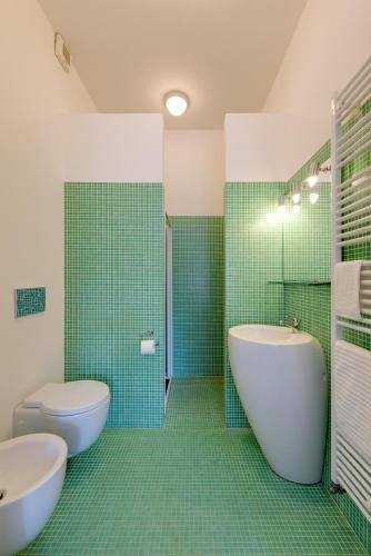 a bathroom with a tub and a toilet and a sink at Scenarium in Udine