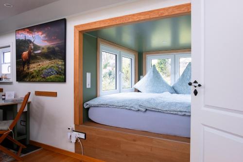 a bedroom with a bed with a window at Ilsehof Tiny-House Mimi in Osterwieck
