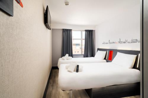 a hotel room with two beds and a window at easyHotel Sheffield in Sheffield