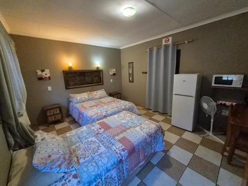 a bedroom with two beds and a refrigerator at N4 Guest Lodge in Rustenburg
