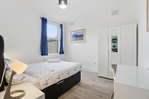 a small bedroom with a bed and a window at Modern 2 bedroom flat, SE6 in Catford