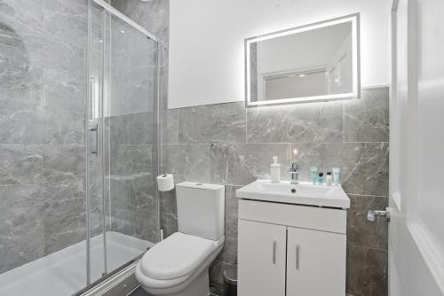 a bathroom with a toilet and a sink and a shower at Modern 2 bedroom flat, SE6 in Catford