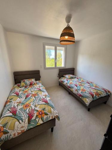 a bedroom with two beds and a window at Le Nid du Cotentin - Maison moderne & calme in Les Pieux