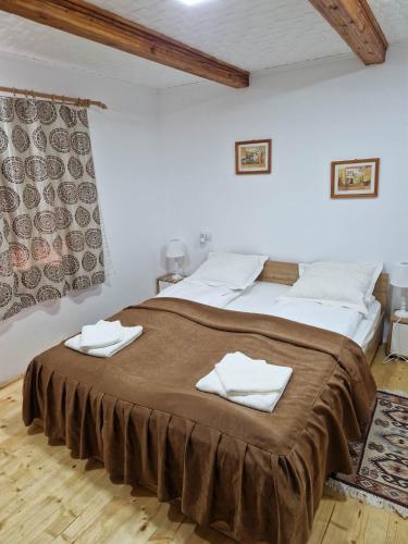 a bedroom with a large bed with towels on it at Casa Marinela in Haţeg