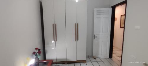a white cabinet in a room next to a door at Casa XV de novembro em Garanhuns in Garanhuns
