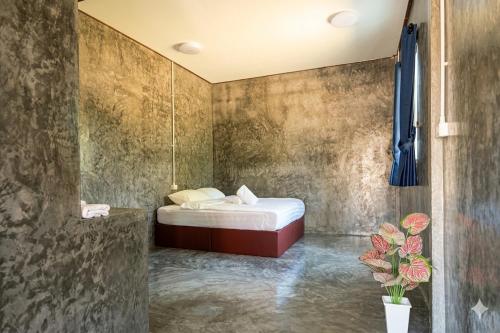 a small bedroom with a bed and a shower at Ban Tew Kao in Ban Nong Chaeng